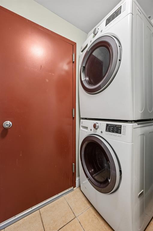 338 Hendrix St, Brooklyn, NY 11207 - laundry area featuring stacked washing machine and dryer and light tile patterned floors