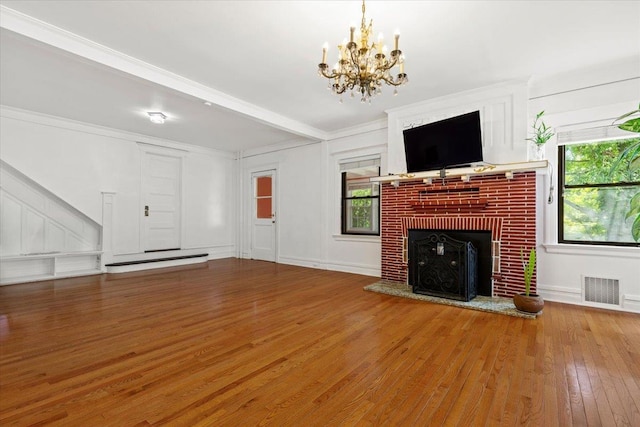 20 The Blvd, New Rochelle, NY 10801 - unfurnished living room with hardwood / wood-style flooring, healthy amount of natural light, a chandelier, a brick fireplace, and crown molding
