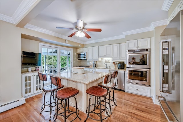 15 Eastover Dr, East Northport, NY 11731 - kitchen with stainless steel appliances, a baseboard heating unit, white cabinets, light stone counters, and light wood finished floors