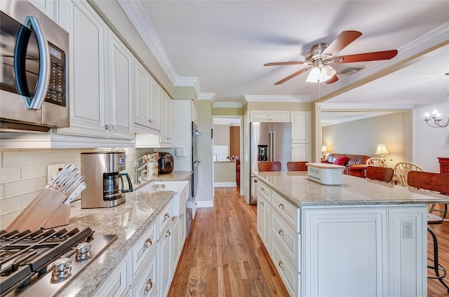 15 Eastover Dr, East Northport, NY 11731 - kitchen with stainless steel appliances, ceiling fan, ornamental molding, light wood-style floors, and white cabinets