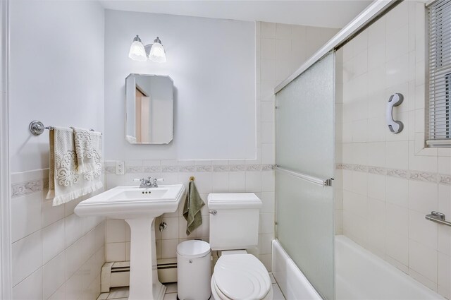 15 Eastover Dr, East Northport, NY 11731 - full bath featuring tile walls, bath / shower combo with glass door, a wainscoted wall, and a baseboard radiator