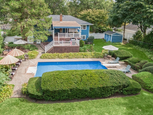 15 Eastover Dr, East Northport, NY 11731 - swimming pool featuring a wooden deck, a fenced backyard, a storage unit, and a patio