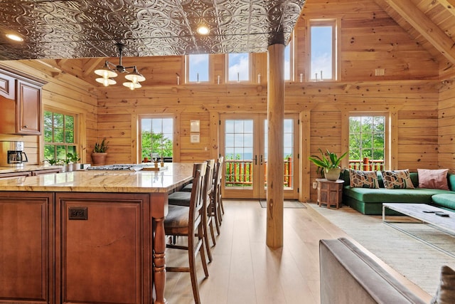 892 Durham Rd, Gilboa, NY 12076 - kitchen with plenty of natural light, a breakfast bar, wood walls, open floor plan, and light wood-style floors