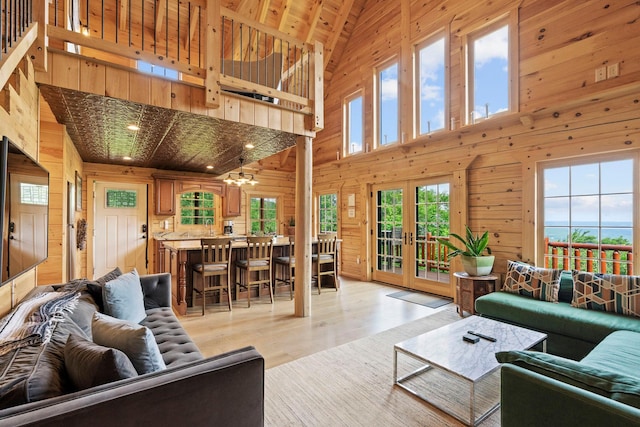 892 Durham Rd, Gilboa, NY 12076 - living room featuring wooden walls, high vaulted ceiling, light wood finished floors, and french doors