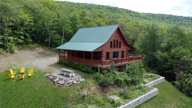 892 Durham Rd, Gilboa, NY 12076 - rear view of house featuring a wooded view, a fire pit, log siding, a wooden deck, and a lawn