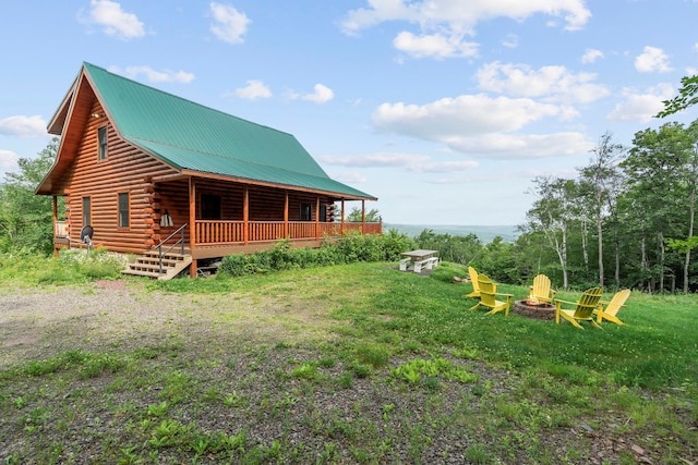 892 Durham Rd, Gilboa, NY 12076 - rear view of property featuring a fire pit, log siding, a metal roof, and covered porch