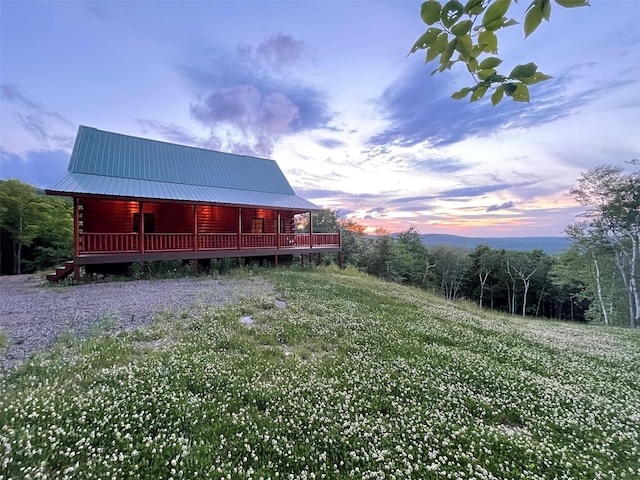 892 Durham Rd, Gilboa, NY 12076 - back of property at dusk with a metal roof, covered porch, and log siding