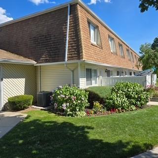172 Storm Dr, Holtsville, NY 11742 - view of side of home featuring a central AC unit and a lawn