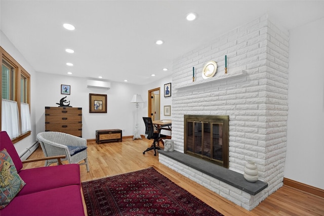 4 Mary Ann Ave, Saugerties, NY 12477 - living area featuring a wall mounted air conditioner, a baseboard heating unit, a fireplace, wood finished floors, and recessed lighting