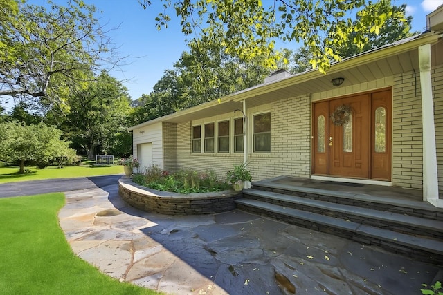 4 Mary Ann Ave, Saugerties, NY 12477 - doorway to property featuring brick siding, a chimney, a garage, and a yard