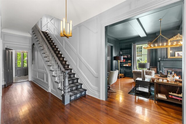 103 Albany Ave, Kingston, NY 12401 - foyer featuring a decorative wall, a chandelier, stairway, and wood finished floors