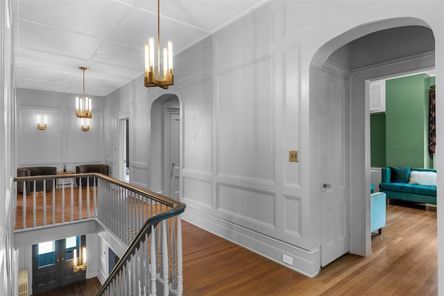 103 Albany Ave, Kingston, NY 12401 - hallway featuring a decorative wall, a chandelier, an upstairs landing, arched walkways, and wood finished floors