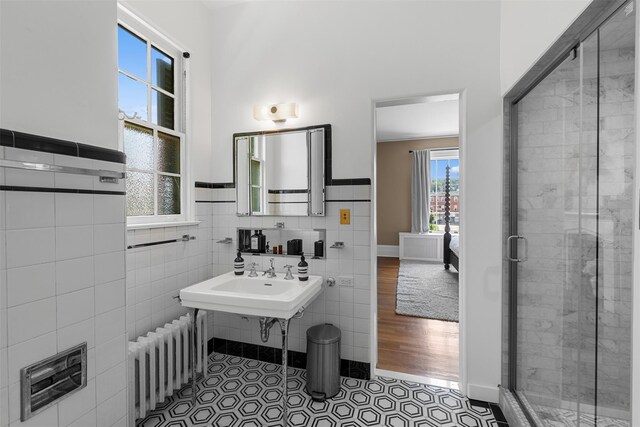 103 Albany Ave, Kingston, NY 12401 - bathroom with radiator, tile walls, a stall shower, a wainscoted wall, and tile patterned flooring