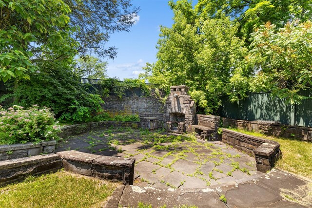 103 Albany Ave, Kingston, NY 12401 - fenced backyard featuring an outdoor stone fireplace and a patio