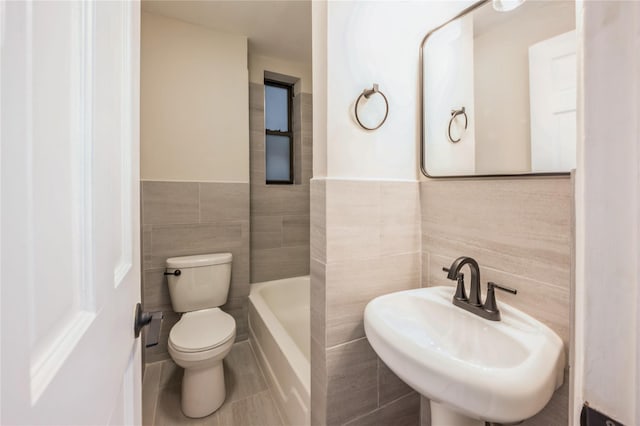 142 E 49th St Unit 4C, New York Manhattan, NY 10017 - full bath featuring tile walls, a bathtub, tile patterned floors, and wainscoting