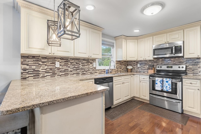 40 Ridge Haven Dr, Ridge, NY 11961 - kitchen with stainless steel appliances, cream cabinetry, dark wood-style flooring, light stone counters, and recessed lighting