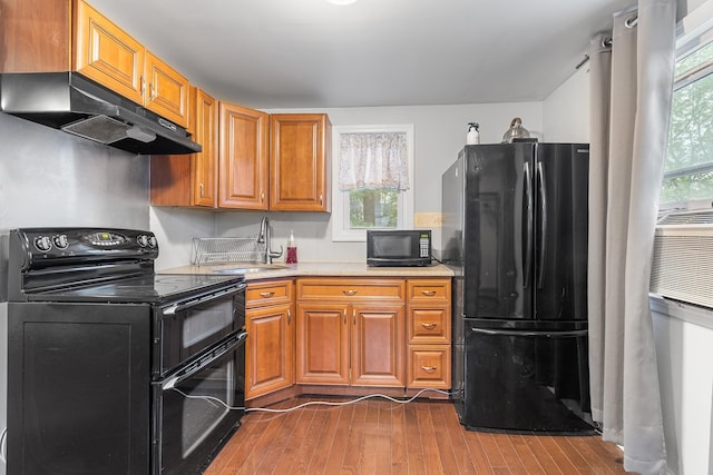 40 Ridge Haven Dr, Ridge, NY 11961 - kitchen featuring black appliances, under cabinet range hood, dark wood-type flooring, and healthy amount of natural light