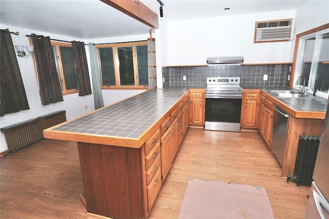 23 Kemble Ave, Cold Spring, NY 10516 - kitchen featuring appliances with stainless steel finishes, radiator, a peninsula, and tile countertops