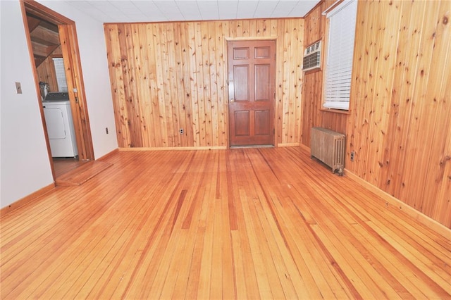 23 Kemble Ave, Cold Spring, NY 10516 - empty room featuring radiator heating unit, washer / clothes dryer, light wood-type flooring, wooden walls, and a wall mounted air conditioner