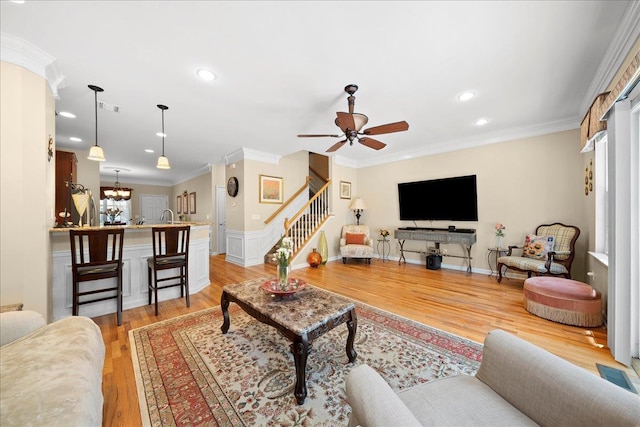 102 Paget Ln, Massapequa, NY 11758 - living room with stairway, light wood finished floors, ceiling fan, ornamental molding, and a chandelier