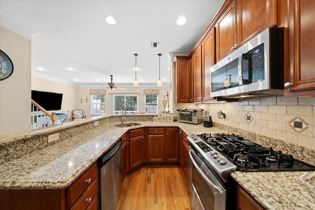 102 Paget Ln, Massapequa, NY 11758 - kitchen with appliances with stainless steel finishes, light wood-style flooring, light stone countertops, a ceiling fan, and decorative backsplash