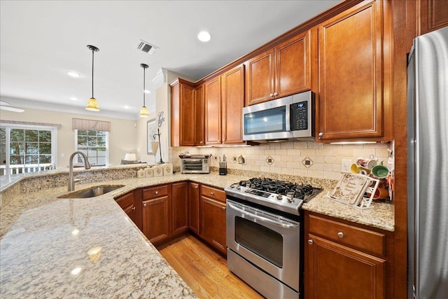 102 Paget Ln, Massapequa, NY 11758 - kitchen featuring appliances with stainless steel finishes, light stone counters, decorative backsplash, brown cabinets, and light wood-style flooring
