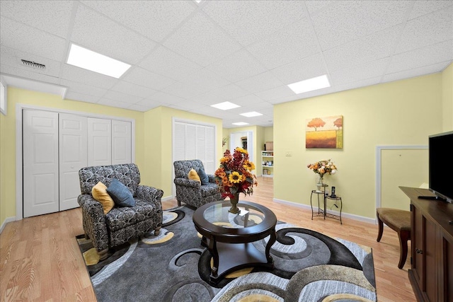 102 Paget Ln, Massapequa, NY 11758 - living area with light wood finished floors and a drop ceiling