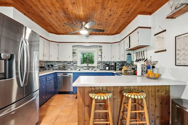 28 Moseman Ave, Katonah, NY 10536 - kitchen featuring stainless steel appliances, blue cabinetry, wooden ceiling, a peninsula, and backsplash