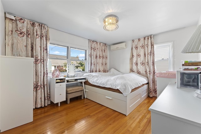 2354 128th St, College Point, NY 11356 - bedroom featuring a wall mounted air conditioner, light wood finished floors, and a chandelier