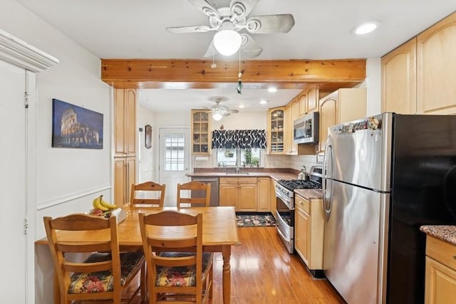 3211 204th St, Bayside, NY 11361 - kitchen featuring stainless steel appliances, ceiling fan, light brown cabinetry, beamed ceiling, and glass insert cabinets