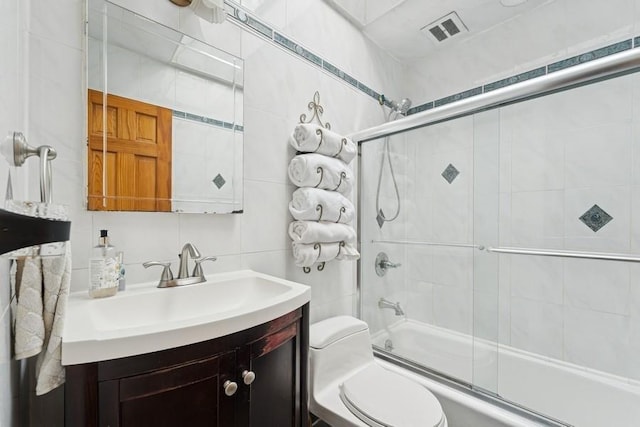 3211 204th St, Bayside, NY 11361 - bathroom featuring combined bath / shower with glass door, vanity, and tile walls