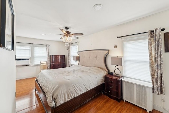 3211 204th St, Bayside, NY 11361 - bedroom with radiator heating unit, wood finished floors, cooling unit, and ceiling fan