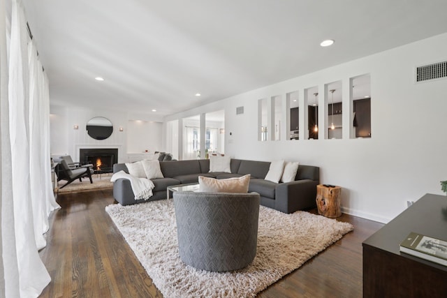 187 Thornbury Rd, Scarsdale, NY 10583 - living area with a warm lit fireplace, dark wood-type flooring, and recessed lighting