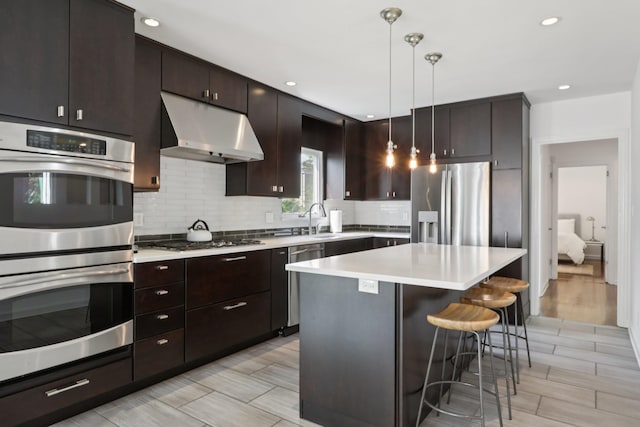 187 Thornbury Rd, Scarsdale, NY 10583 - kitchen featuring stainless steel appliances, under cabinet range hood, a kitchen breakfast bar, decorative backsplash, and light countertops