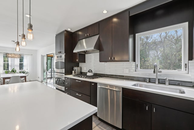 187 Thornbury Rd, Scarsdale, NY 10583 - kitchen with stainless steel appliances, under cabinet range hood, light countertops, backsplash, and recessed lighting