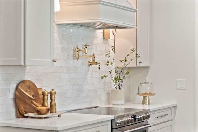 131 Long Pond Rd, Wading River, NY 11792 - kitchen with high end stainless steel range oven, tasteful backsplash, white cabinets, premium range hood, and light stone countertops