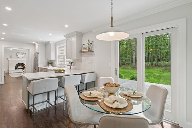 131 Long Pond Rd, Wading River, NY 11792 - dining room with dark wood finished floors, a brick fireplace, recessed lighting, and crown molding