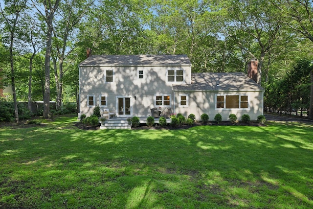 131 Long Pond Rd, Wading River, NY 11792 - rear view of house with a chimney, a yard, and view of wooded area