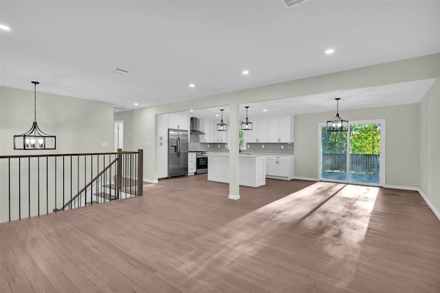 23 White Oak Ln, Bardonia, NY 10954 - unfurnished living room featuring a chandelier, light wood finished floors, and recessed lighting