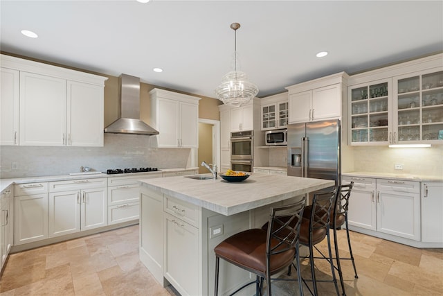 4 Hidden Valley Way, Bedford, NY 10506 - kitchen featuring wall chimney range hood, appliances with stainless steel finishes, stone tile floors, a kitchen breakfast bar, and backsplash