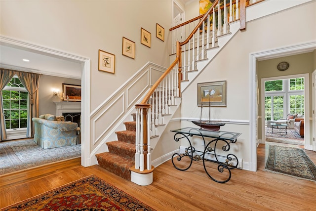 4 Hidden Valley Way, Bedford, NY 10506 - staircase featuring wood finished floors, a fireplace, and a high ceiling