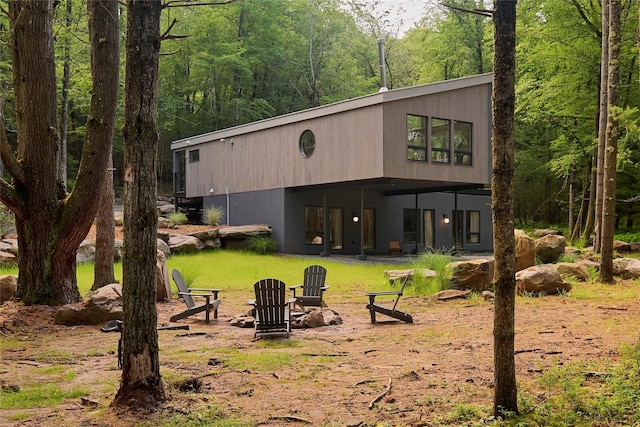 252 Swamp Pond Rd, Narrowsburg, NY 12764 - back of house featuring a wooded view and a fire pit