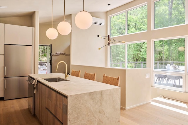 252 Swamp Pond Rd, Narrowsburg, NY 12764 - kitchen featuring appliances with stainless steel finishes, light wood-style flooring, a wall mounted air conditioner, a towering ceiling, and white cabinets