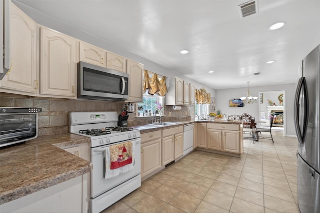 40 Rapelje Rd, Walden, NY 12586 - kitchen with stainless steel appliances, a peninsula, light tile patterned floors, a chandelier, and decorative backsplash
