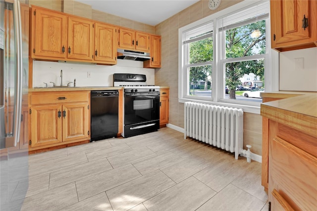 33 Park Cir, New Hyde Park, NY 11040 - kitchen with black dishwasher, range with gas cooktop, radiator, under cabinet range hood, and light countertops