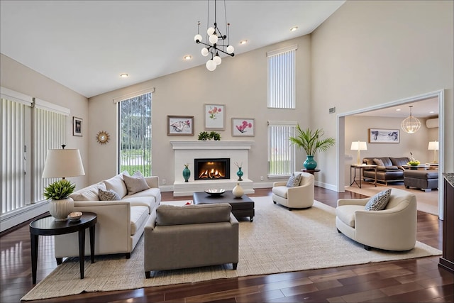 160 Coachman Pl E, Syosset, NY 11791 - living room with wood finished floors, a chandelier, vaulted ceiling, a glass covered fireplace, and recessed lighting