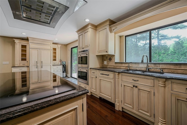 160 Coachman Pl E, Syosset, NY 11791 - kitchen featuring cream cabinetry, ventilation hood, stainless steel double oven, dark wood finished floors, and dark stone counters