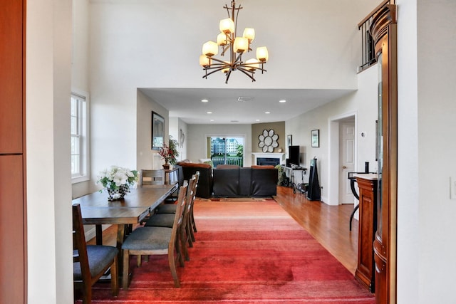 2 Harbor Ln Unit 301, New Rochelle, NY 10805 - dining room featuring wood finished floors, a fireplace, a chandelier, a towering ceiling, and recessed lighting