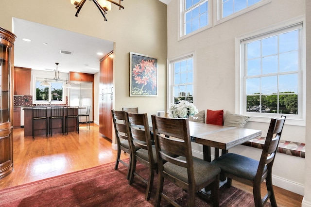 2 Harbor Ln Unit 301, New Rochelle, NY 10805 - dining room featuring wood finished floors, plenty of natural light, a chandelier, a towering ceiling, and recessed lighting