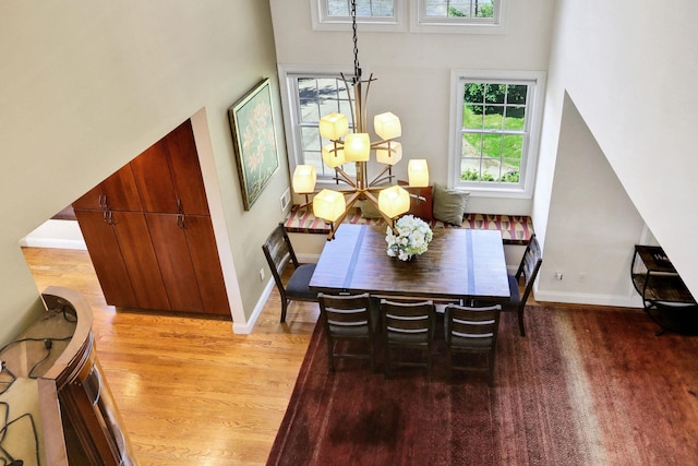 2 Harbor Ln Unit 301, New Rochelle, NY 10805 - dining space featuring plenty of natural light, a towering ceiling, light wood-style flooring, and a chandelier